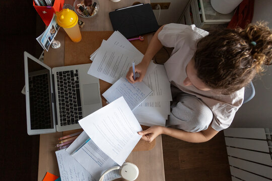 Person studying at home office desk with laptop