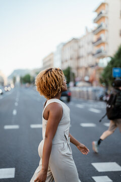 Side view of a woman crossing the street during a walk in the city