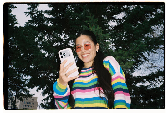Smiling Woman Using Smartphone Outdoors
