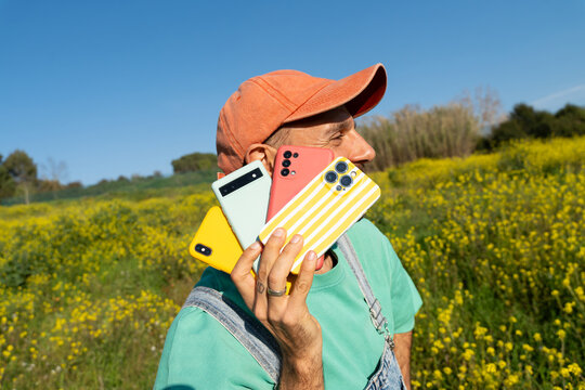 Fun man holding multiple phones 