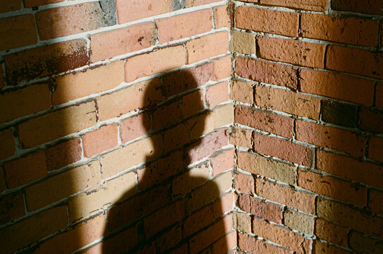 Shadow of a man against a brick wall. 