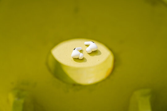 White earbuds in yellow circular opening
