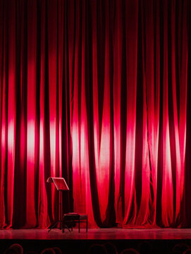 Empty Stage with Music Stand and Red Theatre Curtains