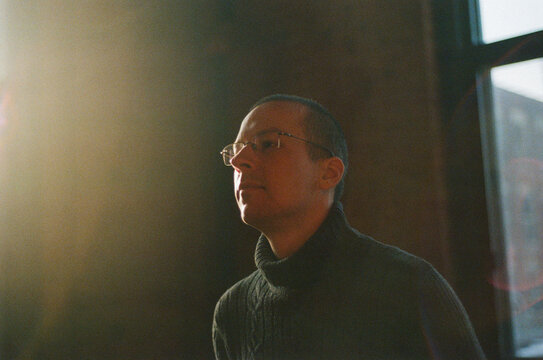 Indoor portrait of a man with sunlight flare