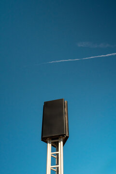 Blank vertical billboard sign against clear blue sky