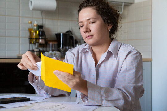 Person opening mail calculating domestic finances
