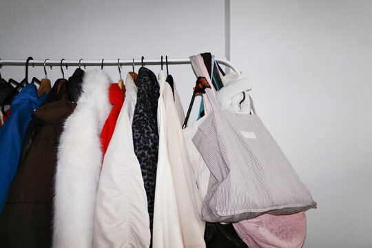 Clothes hanging on a rack with bag and coats, fashion collection