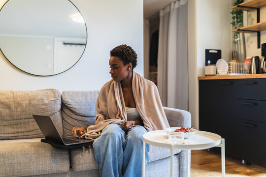 Black Woman with Laptop and Breakfast in Basement Studio