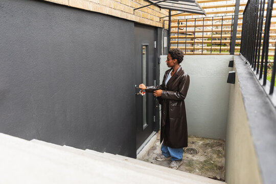 Woman Opening Door to Modern Basement Apartment