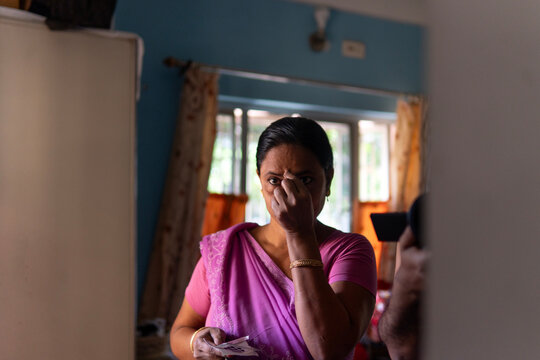 Indian woman wearing traditional dress and wearing BINDI in mirror 