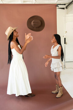 Two People Play With a Hat in a Studio Setting
