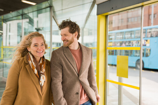 Smiling Couple Walks at Bus Station in Liverpool