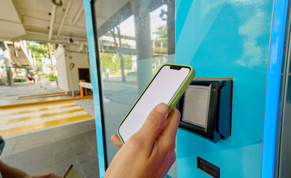 Person tapping smartphone on transit card reader