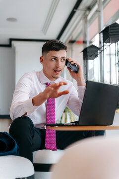 Professional Young Man on a Phone Call While Working