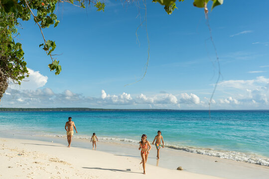 Family exploring wide tropical beach landscape