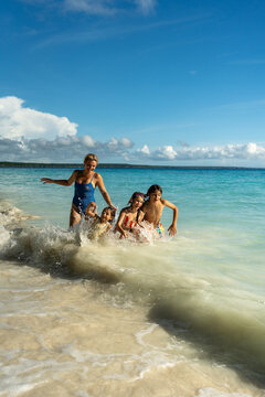 Children playing in breaking ocean waves.