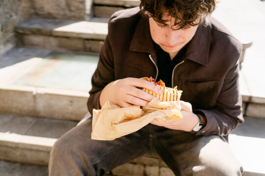young man eating street food in the city of Lyon France