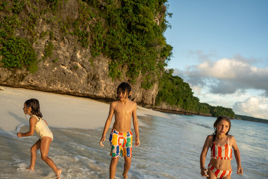 Children running through shallow waves