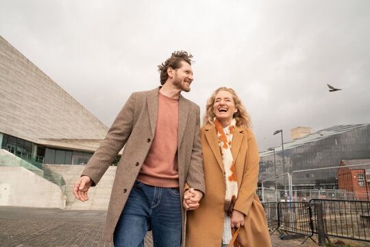 Couple Walk Hand in Hand Along the Waterfront in Liverpool