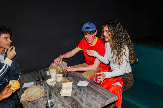 Friends cheering and celebrating watching game in a bar