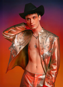 Man in a gold cowboy outfit with fringe jacket and cowboy hat 