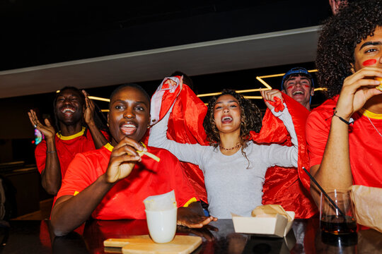 Cheering fans celebrating sport watching match