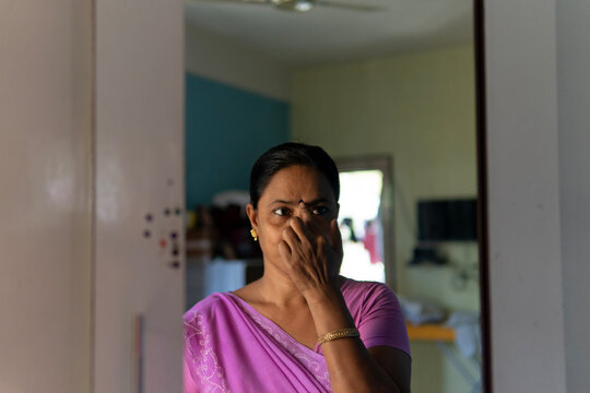 Indian woman wearing traditional dress and wearing BINDI in mirror 