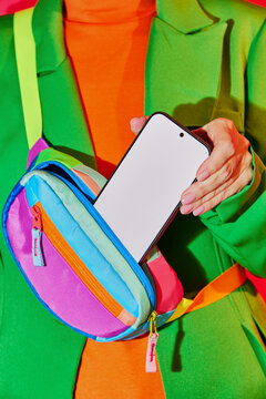 Person Pulling Smartphone from Colorful Waist Bag. Blank, mock-up. 