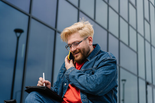 Man talking on phone while writing
