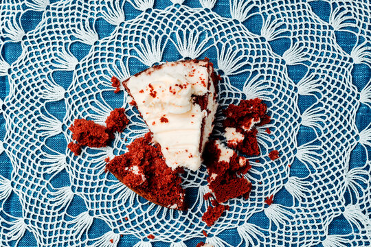 fragments of red velvet cake lie on a lace doily