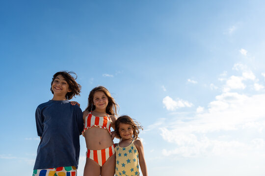 Sibling standing together under blue sky