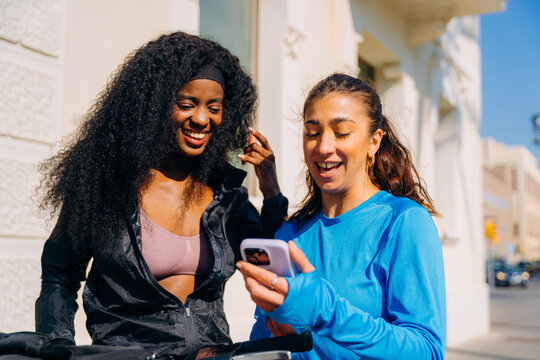 Two women use a mobile phone after sports