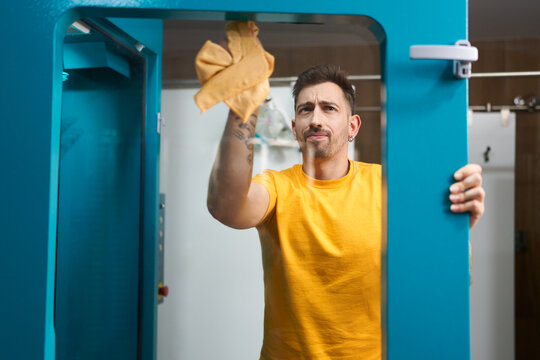 Man cleaning glass door in dive center