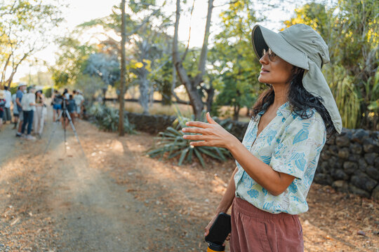 Woman tour guide leading group exploring nature path