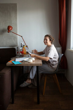 Person studying online at home office desk enjoying remote work