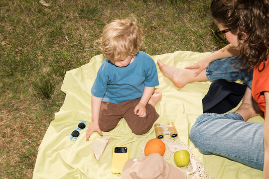 Family enjoys spring picnic in nature with colorful snacks and fun