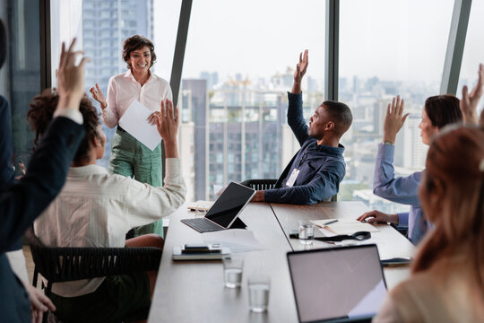 Business meeting with hands raised in agreement.