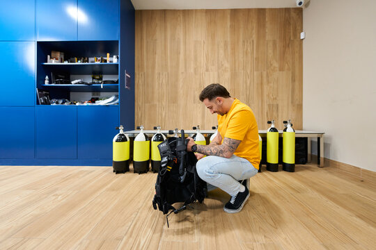 Man preparing diving equipment at dive center