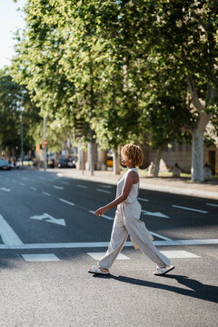 A woman crossing the street while walking in the city