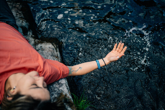 Person Plays With Water at a River During the Day
