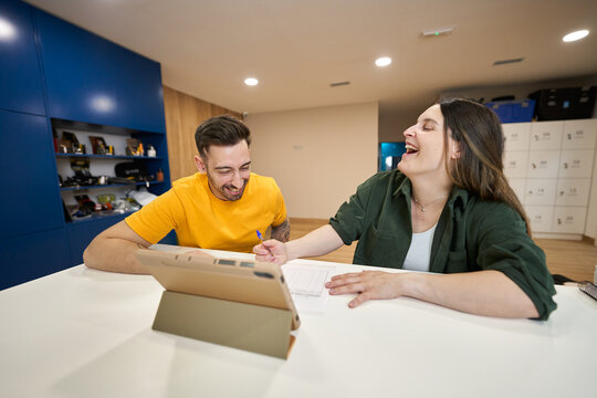 Happy people laughing while signing paperwork at reception