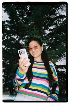 Smiling Woman Using Smartphone Outdoors