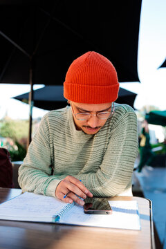 Student man using phone while studying