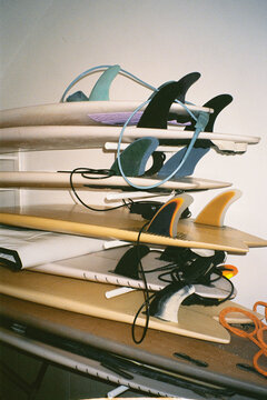 Analog medium shot of several surfboards piled on top of one another
