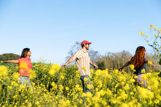 Friends Walking In Flower Field Together