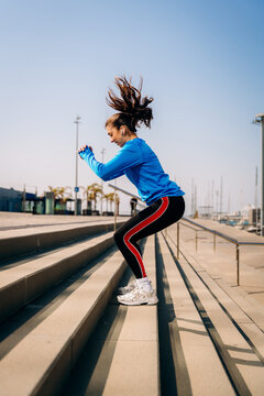 A woman does exercises on the stairs