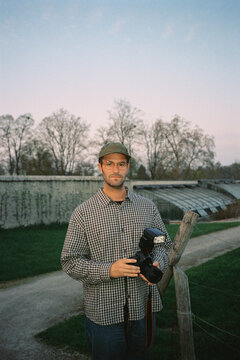 Analog portrait of a tourist photographer posing outside a country inn