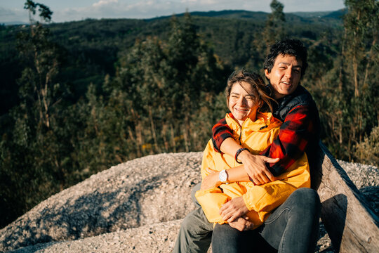 Couple Enjoying Time Together on a Hillside During a Sunny Day