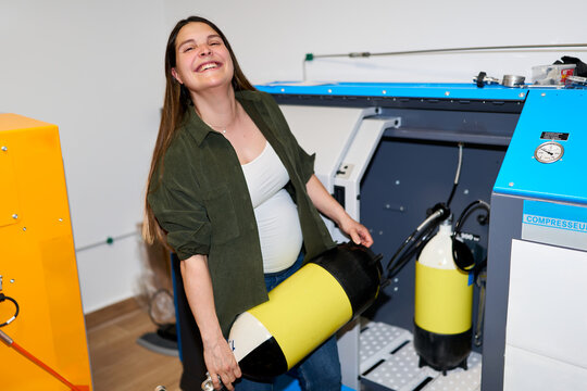 Pregnant woman smiling working at a dive center