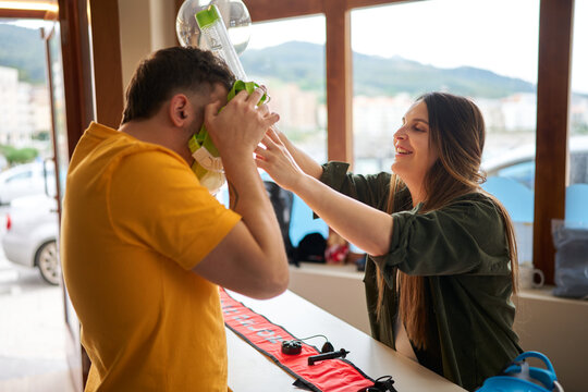 Instructor helping man trying on snorkeling mask